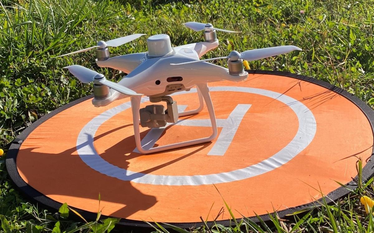 Drone posé au sol dans un champ